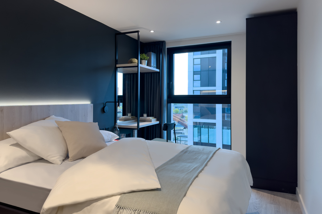 studio apartment bed, desk and window