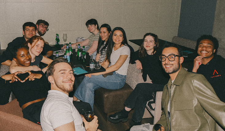 group of people smiling at table with drinks